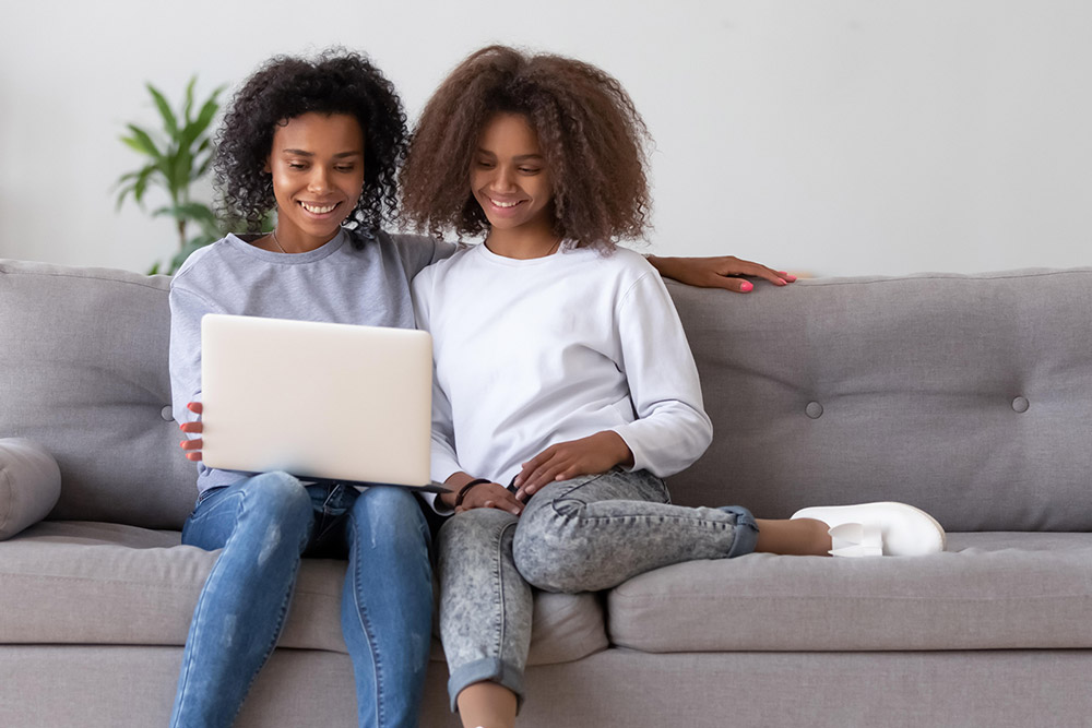 Brainline student doing homework with mom on a laptop